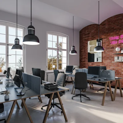 Moderner Büroraum mit mehreren Arbeitsplätzen, großen Fenstern, Pendelleuchten und einer markanten Backsteinwand in der Bergstraße 1 in Berlin.