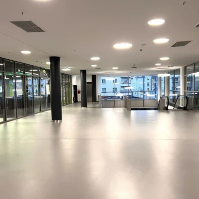 Heller Eingangs- und Erschließungsbereich mit Glasfronten, Aufzug und Rolltreppe in der Gewerbeimmobilie Berliner Straße 206–216 in Offenbach am Main.