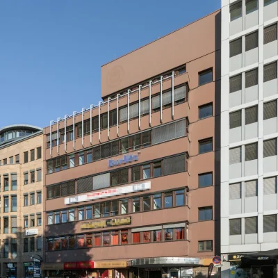 Außenansicht der Gewerbeimmobilie an der Bismarckallee 2 in Freiburg mit Ladenflächen im Erdgeschoss und Büroflächen in den oberen Etagen.