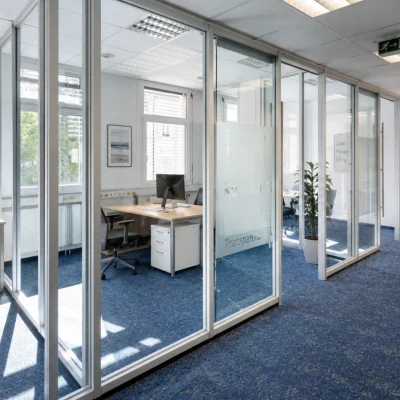 Moderne Bürofläche mit verglasten Besprechungsräumen und hellen Arbeitsbereichen in der Bismarckallee 2 in Freiburg.