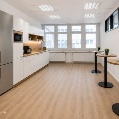 Helle Büroküche mit Einbauküche, Stehtischen und Aufenthaltsbereich in der Bismarckallee 2 in Freiburg.