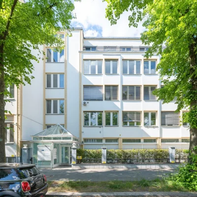 Frontansicht der Büroimmobilie Heerstraße 24 in Berlin mit heller Fassade, großen Fenstern und begrüntem Straßenraum.