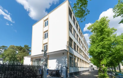 Straßenansicht der Büroimmobilie Heerstraße 24 in Berlin mit heller Fassade und grünen Bäumen bei sonnigem Wetter.