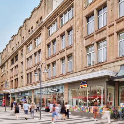 Historische Kaufhausfassade mit Ladengeschäften entlang der Fußgängerzone