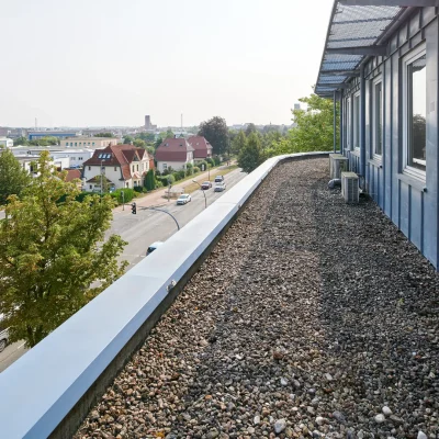 Dachterrasse mit Kiesbelag und Blick über Wohnbebauung bis zum Hafen