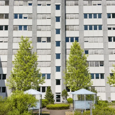 Innenhof des Bürokomplexes mit Eingang, Fahrradunterständen und jungen Bäumen