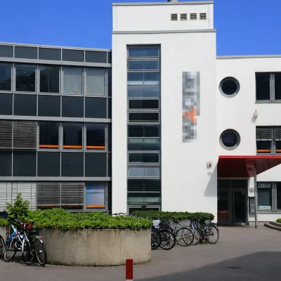 Innenhof des Gebäudekomplexes mit Fahrradstellplätzen und rotem Eingangsvordach
