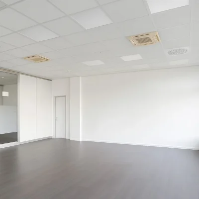 Leere Bürofläche mit Holzboden, Glasbüro und großer Fensterfront