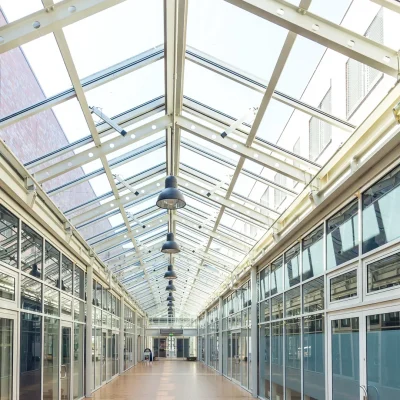 Lichtdurchflutete Ladenpassage mit Glasdach und Geschäften auf beiden Seiten