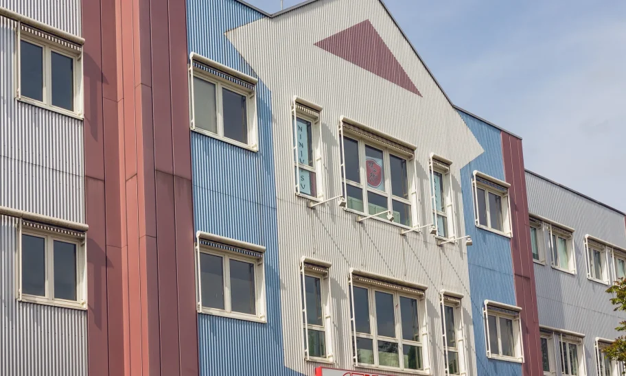 Fassadendetail mit bunter Wellblechverkleidung und asiatischer Beschriftung