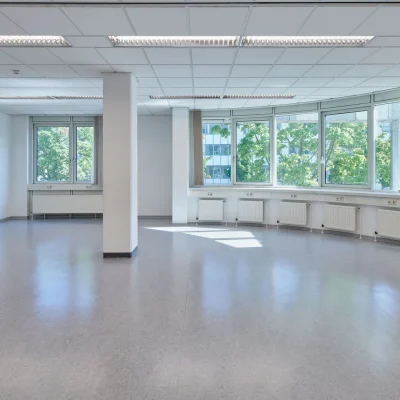 Leeres Büro mit Rundfenster, Säule und Blick ins Grüne
