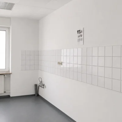 Leerer Raum mit weißen Fliesen, Fenster und Heizkörper für künftige Teeküche