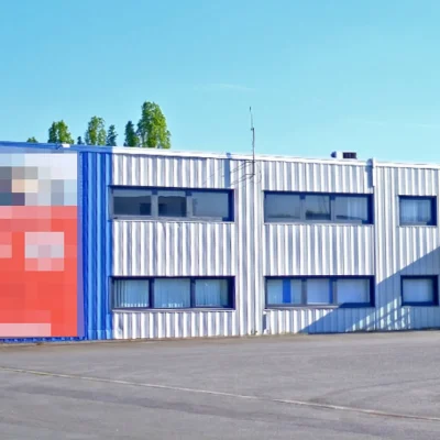 Gewerbegebäude in Blau-Weiß mit großformatiger Werbetafel an der Fassade