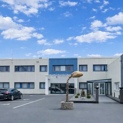 Gewerbegebäude mit Eventlocation-Schriftzug, Kutschwagen und Deko-Skulpturen