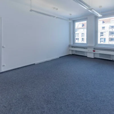 Leeres Büro mit blauem Teppichboden und Doppelfenster