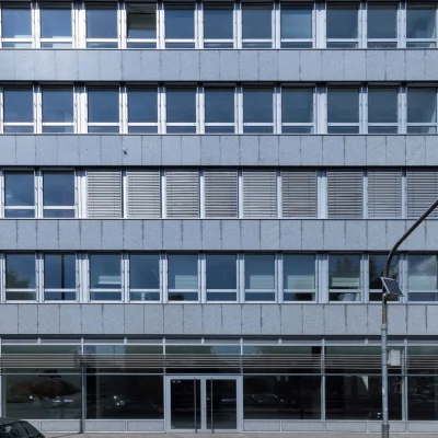 Bürogebäudefassade mit Rasterfenstern und Sonnenschutzlamellen