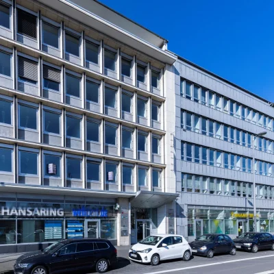Gebäudefassade mit Zahnklinik-Schriftzug im Erdgeschoss