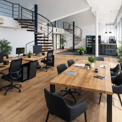 Loft-Büro mit Galerie, Wendeltreppe, Holzschreibtischen, Pflanzen und hoher Fensterfront (KI-Visualisierung)