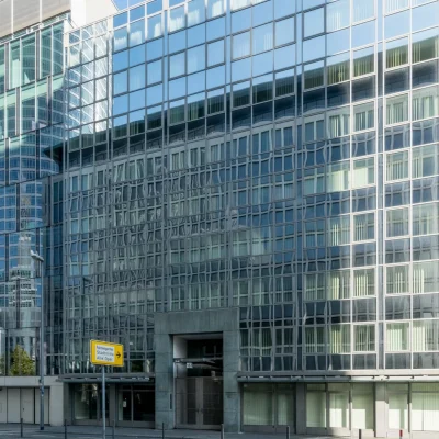 Bürogebäude Karlstraße 16 in Frankfurt mit spiegelnder Glasfassade und Eingangsportal an der Straße