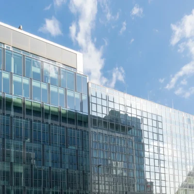 Bürogebäude mit Glasfassade und Staffelgeschoss neben einem Hotel an einer Hauptstraße in Frankfurt