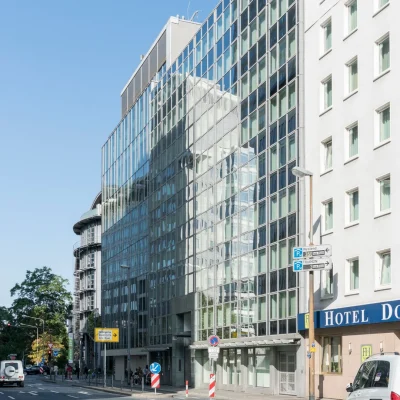 Bürogebäude mit spiegelnder Glasfassade an der Karlstraße in Frankfurt, im Straßenverlauf neben einem Hotel