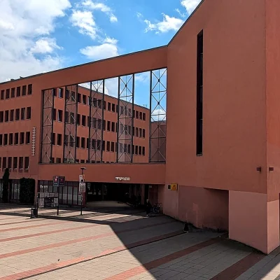 Eckansicht des orangefarbenen Jobcenter-Gebäudes mit spitz zulaufender Fassade