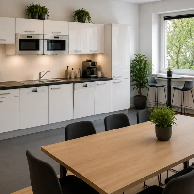 Teeküche mit weißer Einbauküche, Getränkekühlschrank und Esstisch mit Barhockern