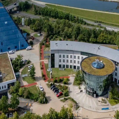 Luftaufnahme des Gebäudekomplexes mit begrüntem Dach und Glaspyramide