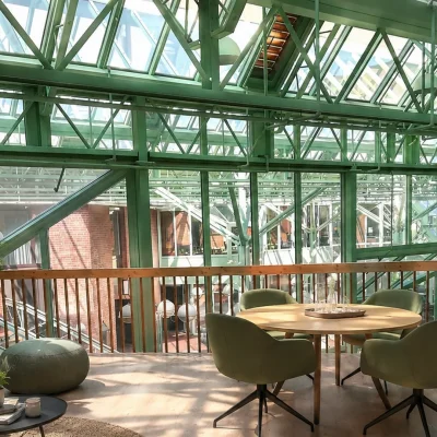 Dachterrassen-Lounge mit grüner Stahlkonstruktion, Sofa und Rundtisch