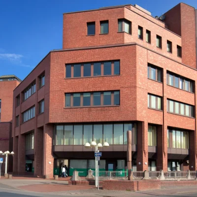 Eckansicht des Bürogebäudes mit Backsteinfassade und Straßenszene