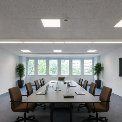 Großer Konferenzraum mit langem Tisch, Bildschirmen und braunen Stühlen