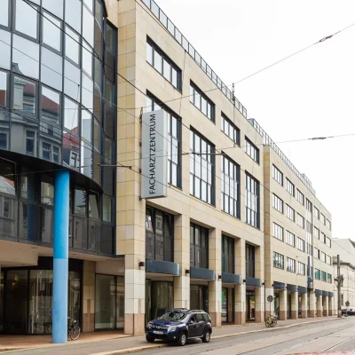 Straßenansicht des Facharztzentrums mit Sandsteinfassade bei bewölktem Himmel