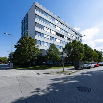Eckansicht des Bürogebäudes mit Glasfassade und angrenzendem Wohnturm