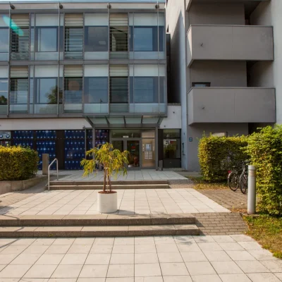 Eingangsbereich mit Terrasse, Pflanzkübel und begrüntem Vorplatz
