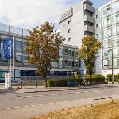 Bürogebäude 'Apartmenthaus International' mit Bäumen und Fahnenmasten davor