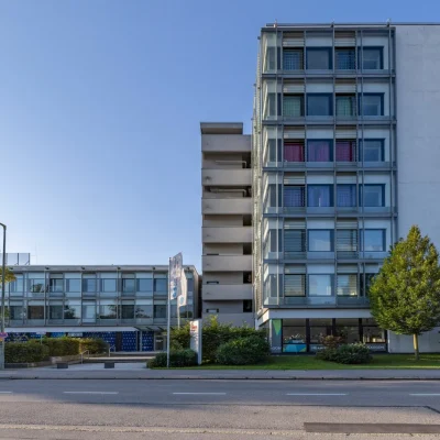 Weite Straßenansicht des Hexagon-Bürogebäudes mit Grünflächen