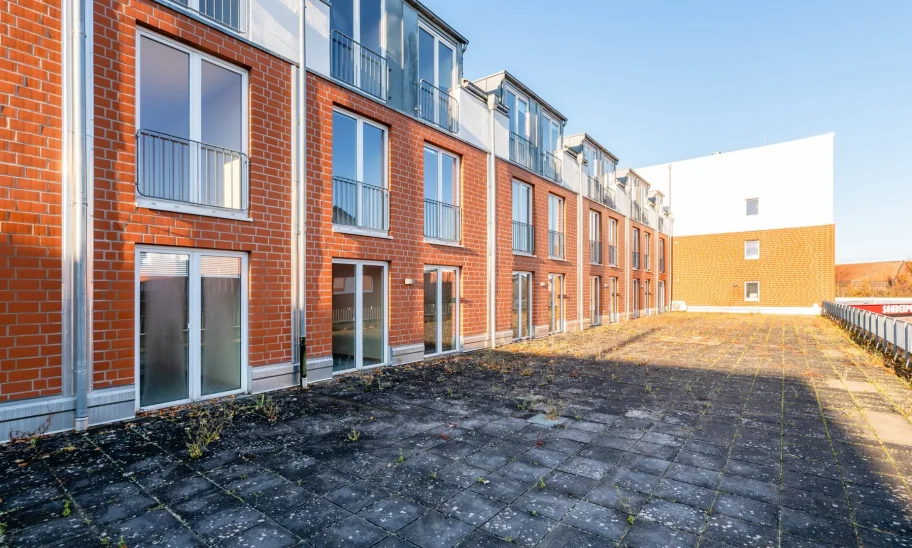 Backsteinfassade des Gebäudekomplexes mit Dachterrasse in Perspektive