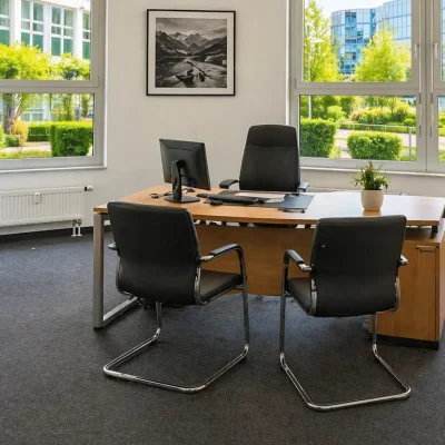 Einzelbüro mit Eckfenstern, Schreibtisch und Aussicht auf Nachbargebäude