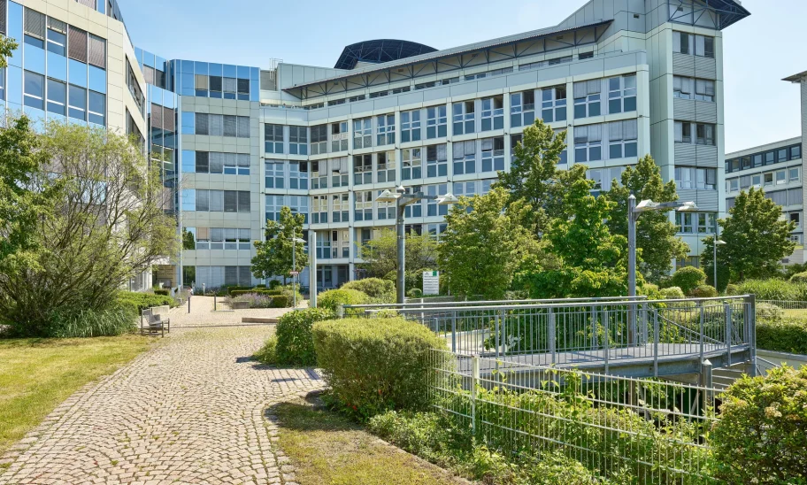 Bürogebäude mit markanter Eckfassade und begrüntem Vorplatz