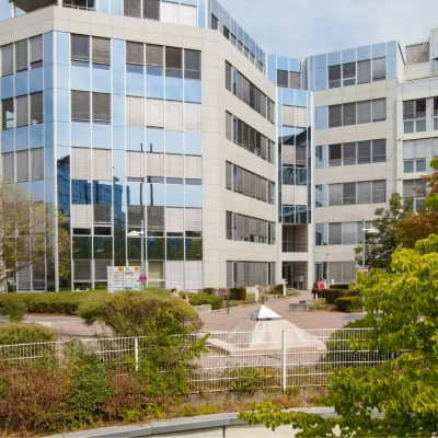 Modernes Bürogebäude mit Glasfassade und grüner Außenanlage