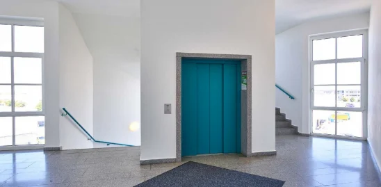 Heller Eingangs und Erschließungsbereich im Gutenberg Center München mit Aufzug, Treppenhaus und großzügigem Tageslichteinfall.